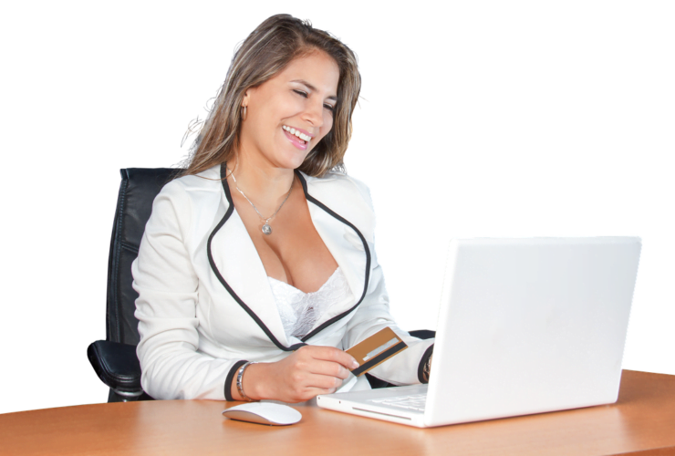 Frau mit Smartphone sitzt an einem Laptop