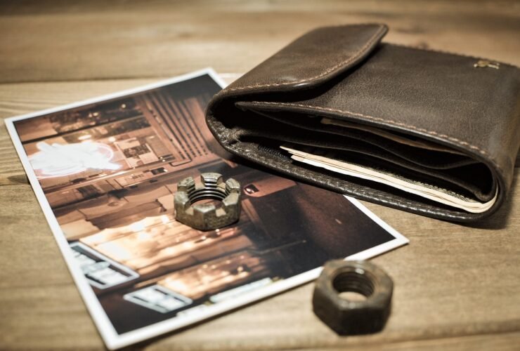 Geldbeutel, Fotoabzüge und ein Ring auf einem Tisch