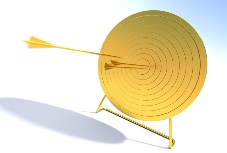 Goldene Zielscheibe mit einem Pfeil im Zentrum