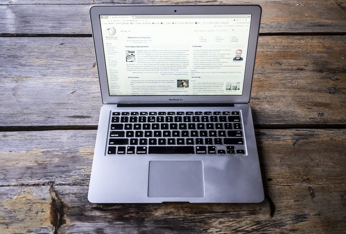 Laptop mit geöffneter Website auf einem Holztisch