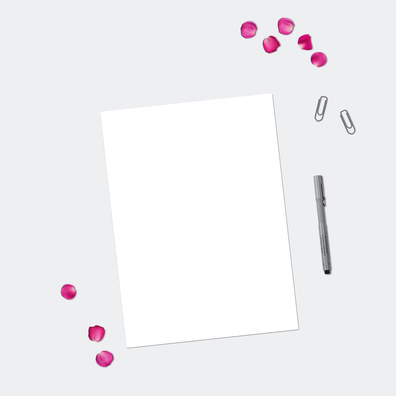 Leeres Blatt mit Stift und rosa Konfetti