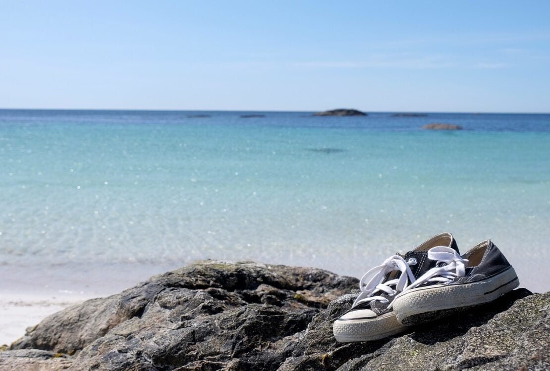 Sneaker liegen auf einem Felsen am Meer