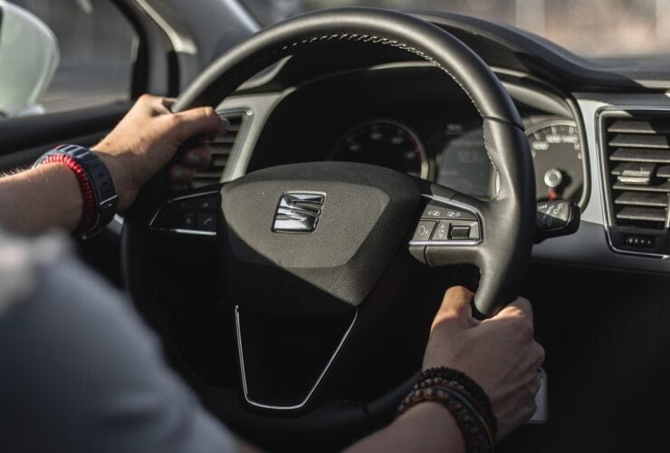 Hände am Lenkrad eines Autos im Innenraum