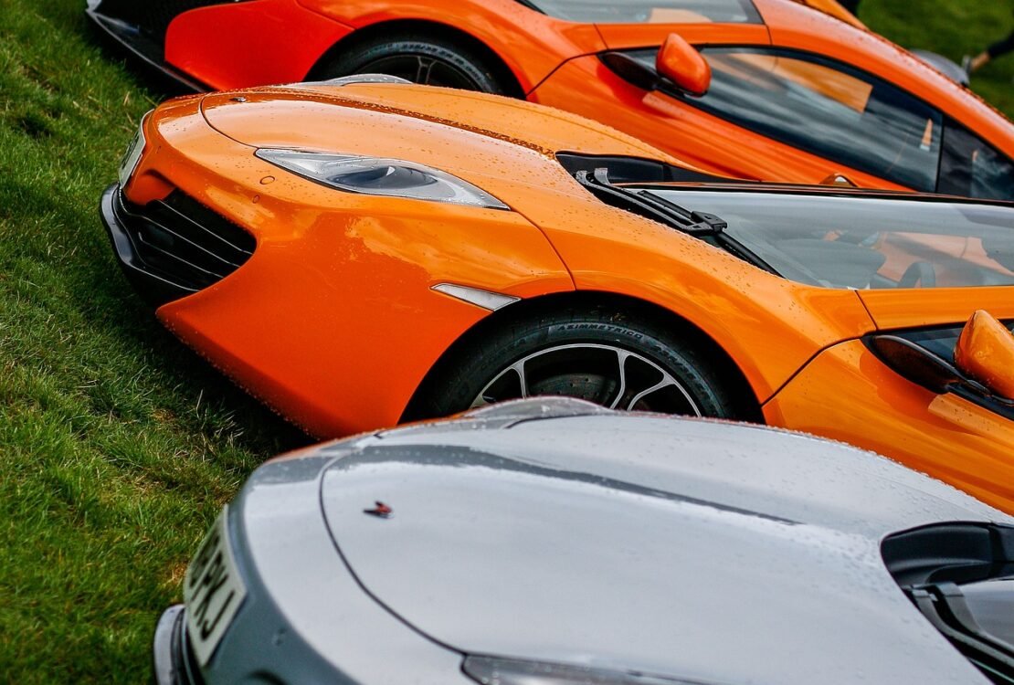 Orange und weiße Sportwagen stehen nebeneinander