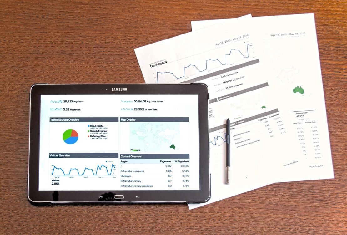 Tablet mit Diagrammen neben Papieren auf einem Tisch