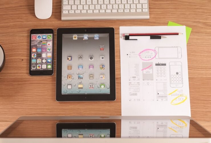 Schreibtisch mit Tablet und handgezeichneten Entwürfen